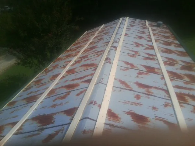 Rusted metal roof panels with new wood purlins before replacement — Storm Damage Roof Repair in Sardinia by Roofing Brothers