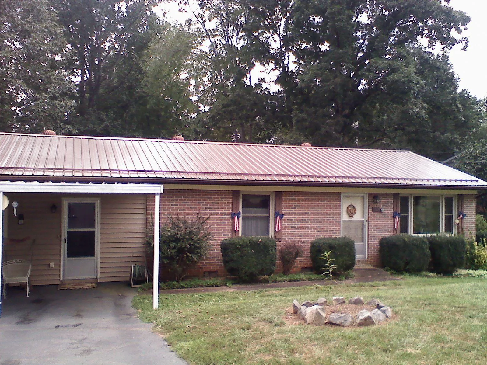 Bronze metal roof and carport on a brick ranch home — Roof Repair work by our crew in Sardinia