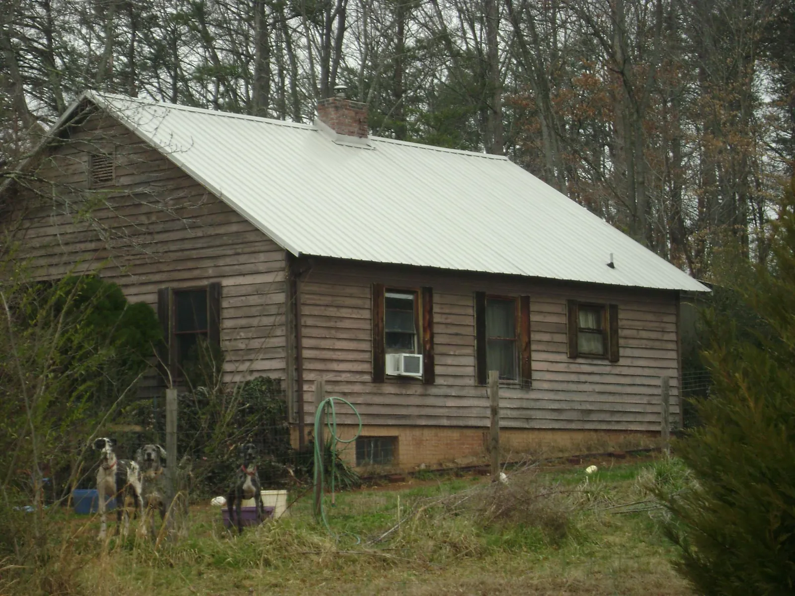 White metal roof on an old wood sided farmhouse, from a Metal Roof Installation job in Sardinia